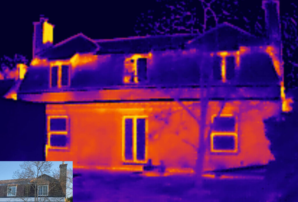 Thermal image of a two-storey house with sash windows Cambridge, highlighting heat loss around windows, roof, and chimney. A small inset photo in visible light appears at the bottom left.